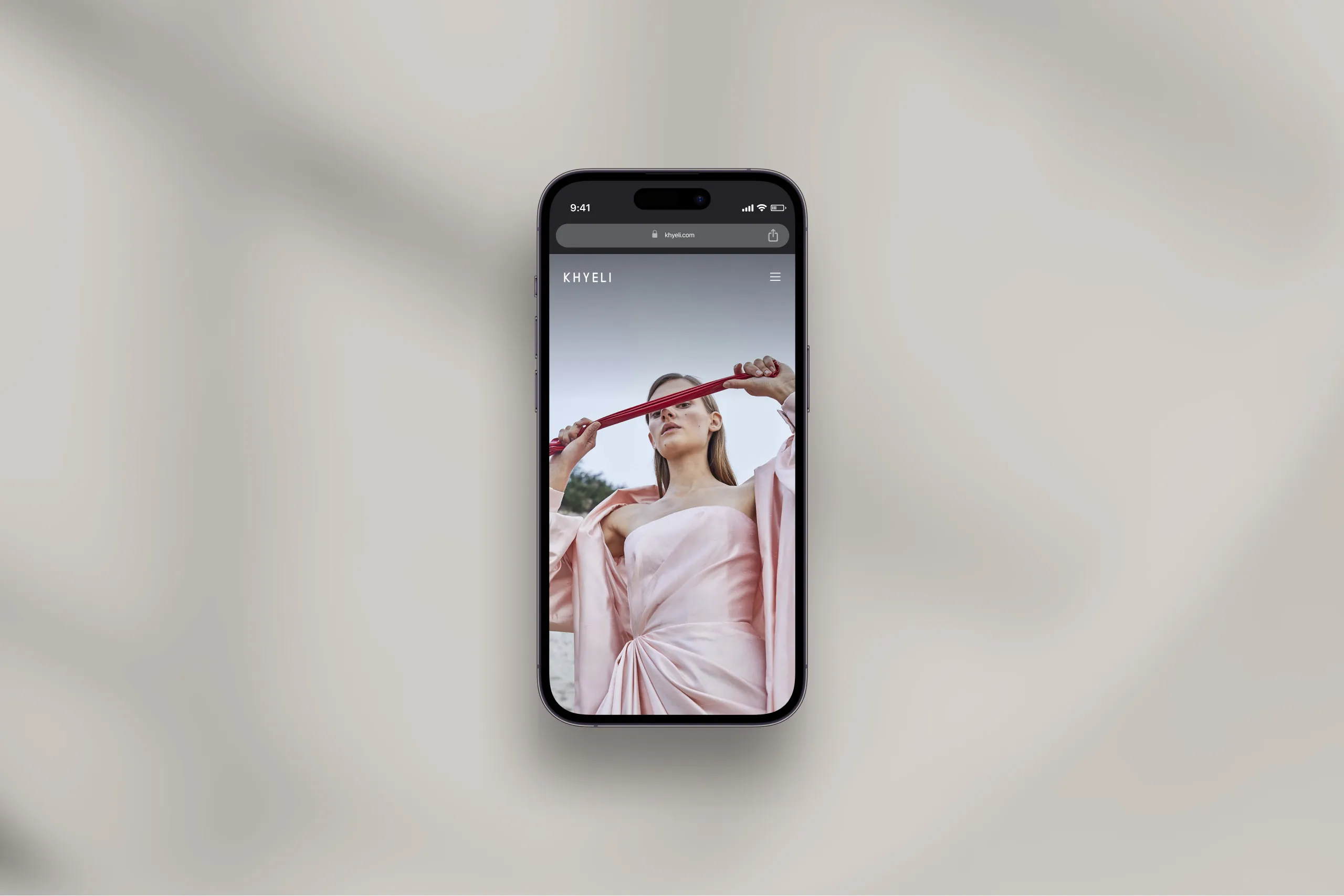 Photo of the Khyeli website, displayed on an iPhone laying flat on a desk.