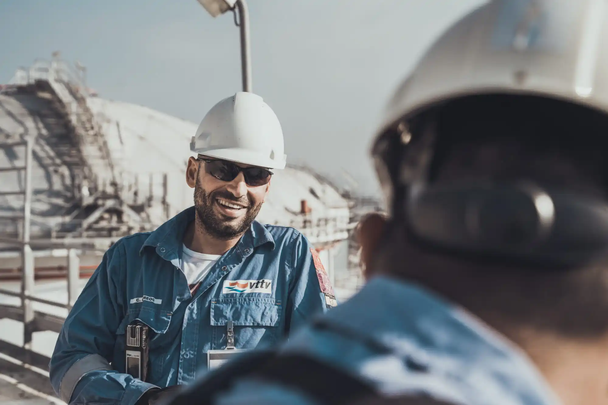 Photograph of 2 VTTI workers conversing near an energy storage terminal